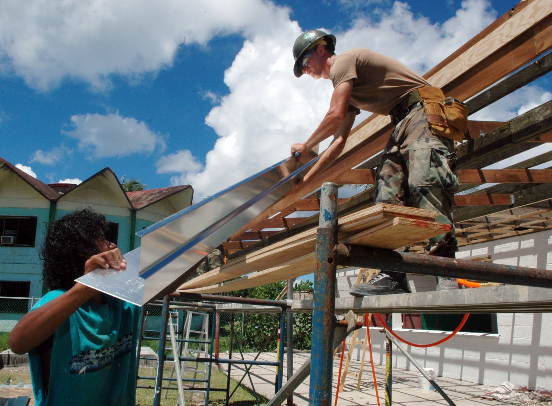 Construction worker installing wood framing and drywall panels

